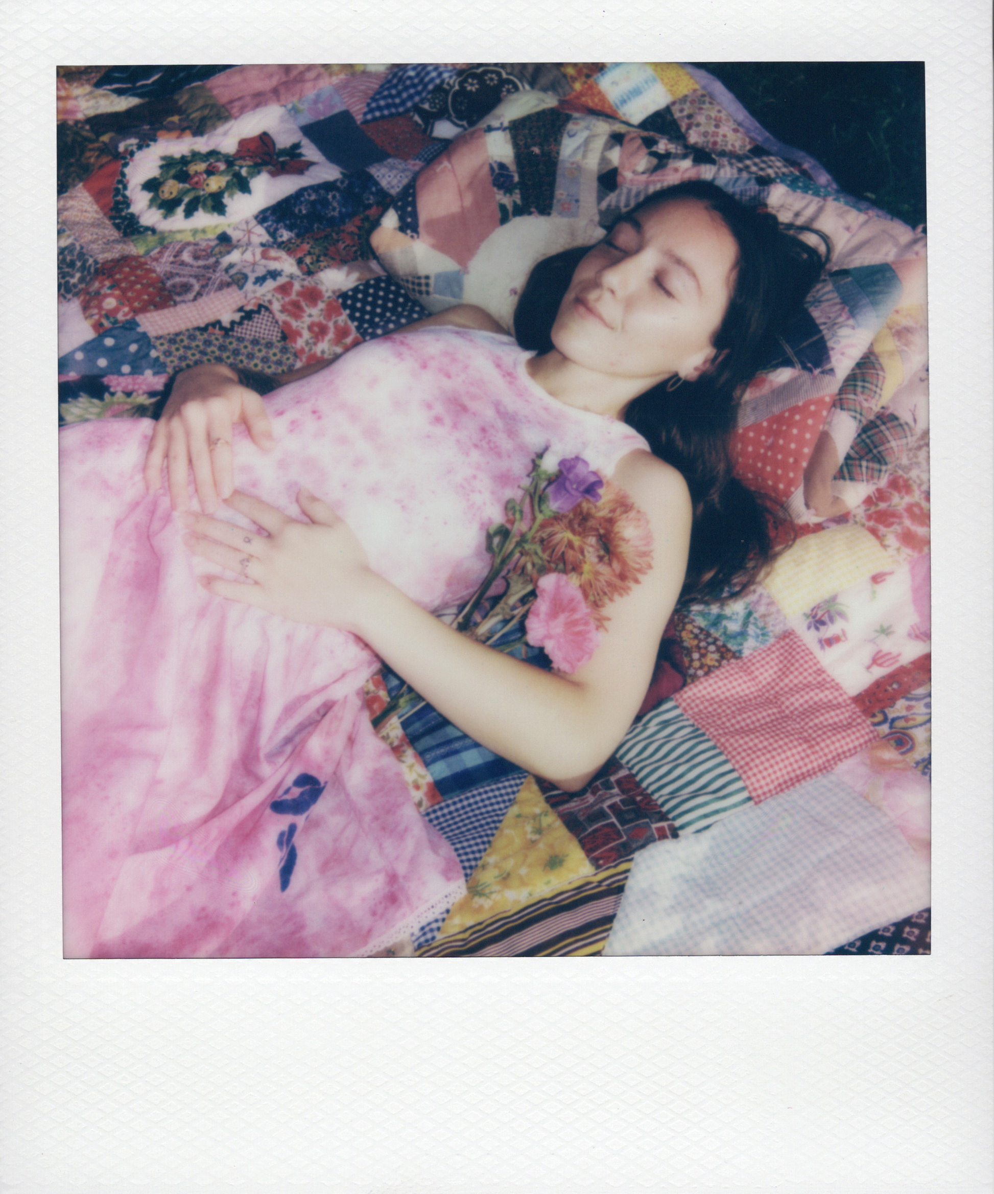 Rebecca wearing a hand dyed slip dress, lying on a vintage quilt